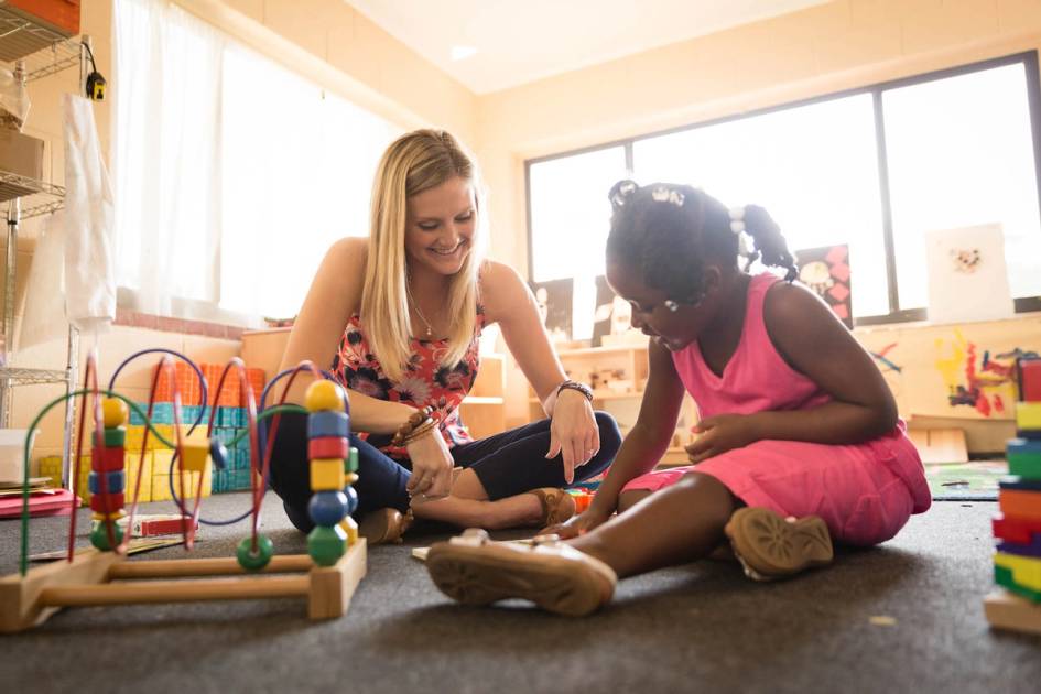 Child and teacher play on the floor