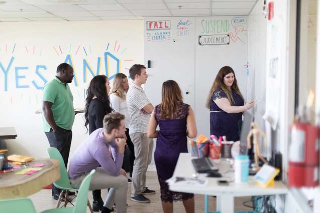Social innovation and entrepreneurship students working with their mentor in the social impact hub on campus.