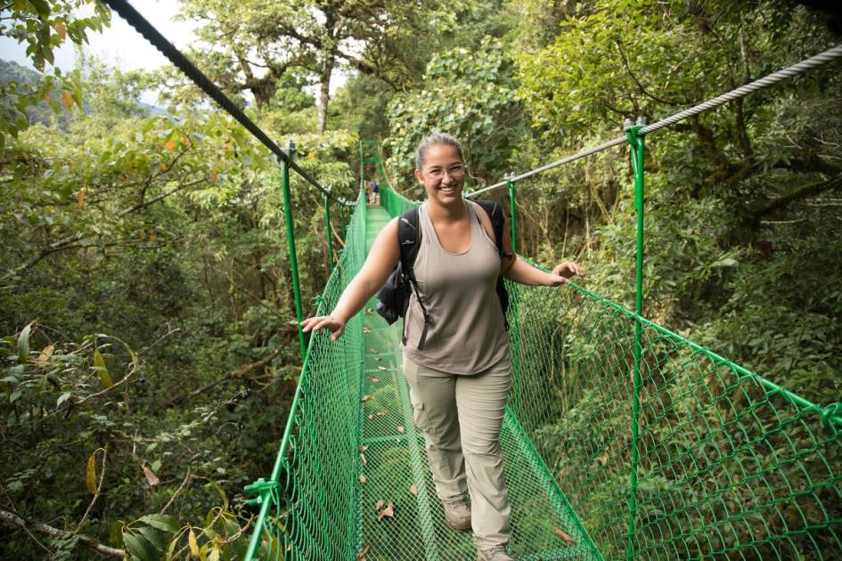 Rollins student crossing rope bridge in Costa Rica forest.