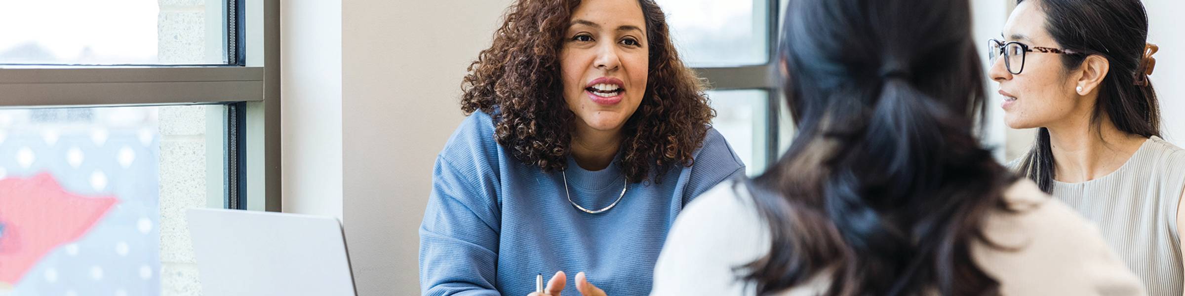 A group of graduate counseling students chats during a break from class.
