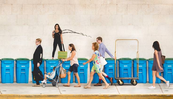 Avani Mooljee pictured on top of recycling bins illustrating her commitment to the environment and sustainability.