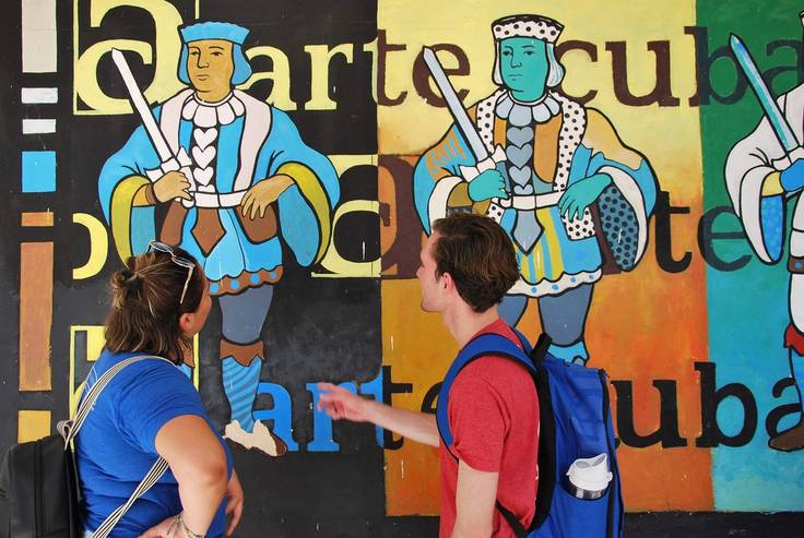 Rollins students discuss an art mural on a field study to Cuba.