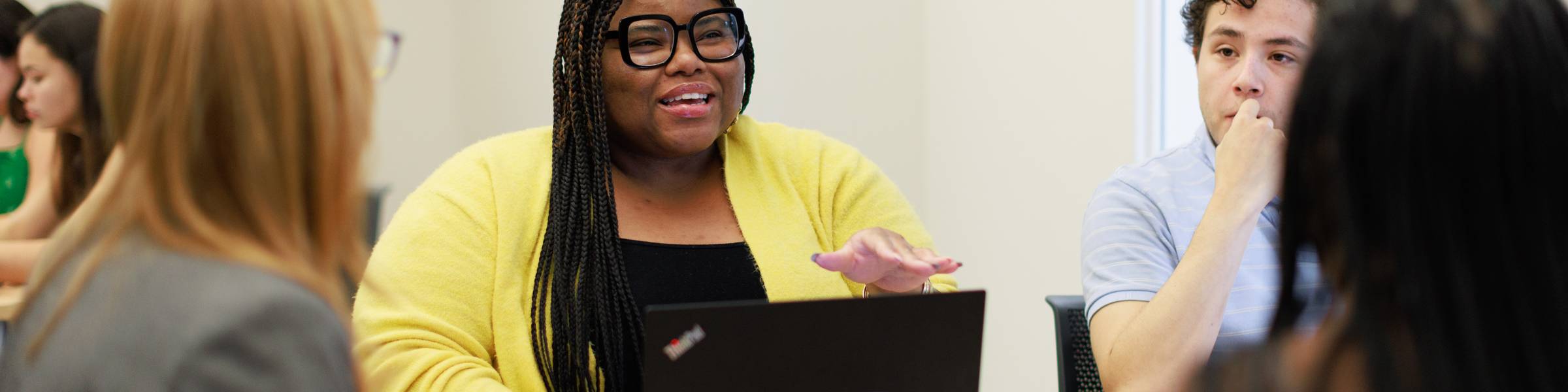 A communications studies student at Rollins College discusses a topic with her professor and classmates.