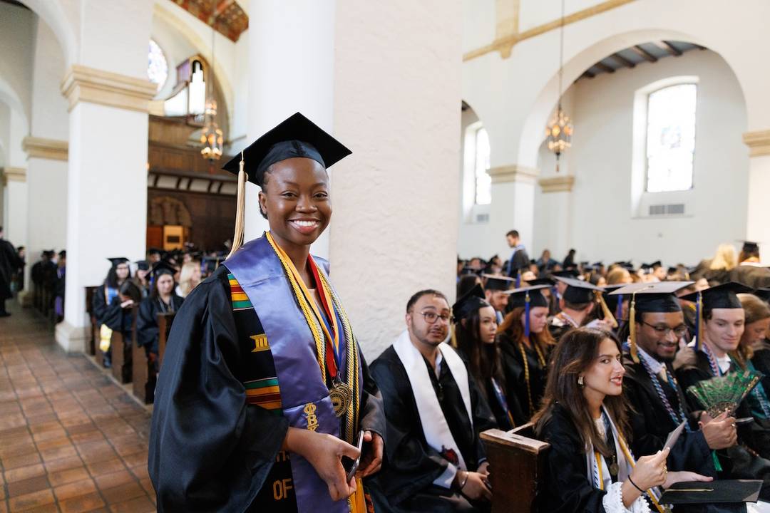 Graduates posing in Knowles Memorial Chapel before commencement. 