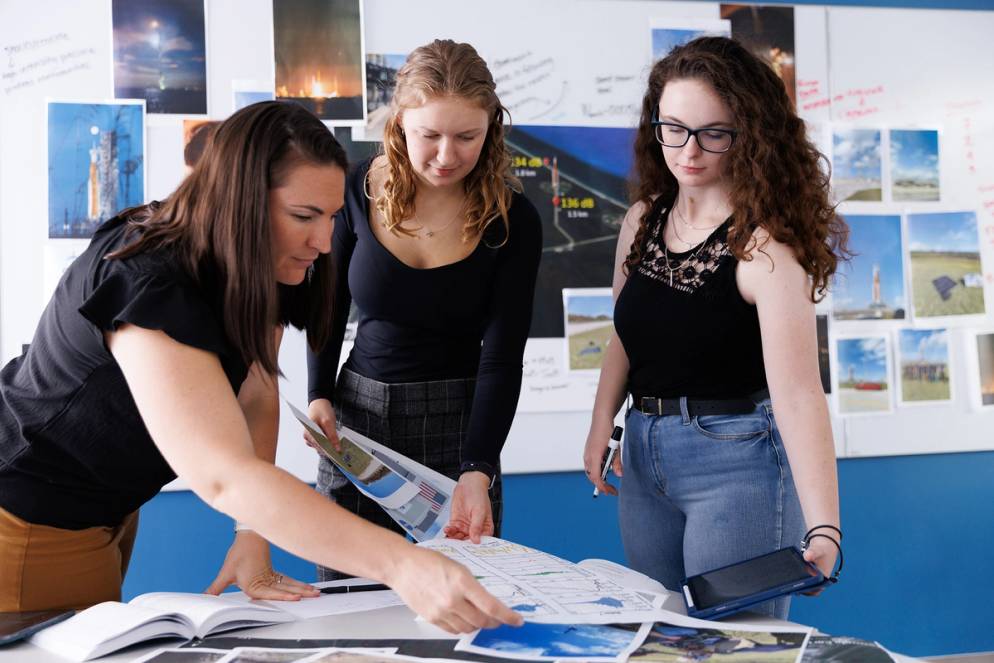 Physics professor Whitney Coyle (left) works with physics students Makayle Kellison ’25 and Maggie Kuffskie ’25 to analyze findings from their acoustical research on the launch of the Artemis I rocket.