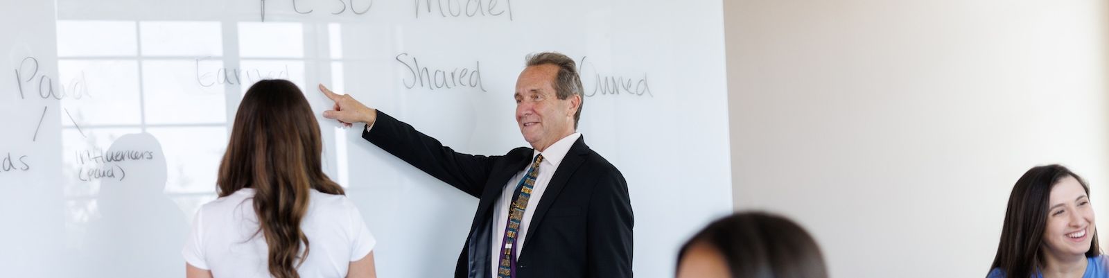 A communications professional leads a meeting with a group of colleagues.