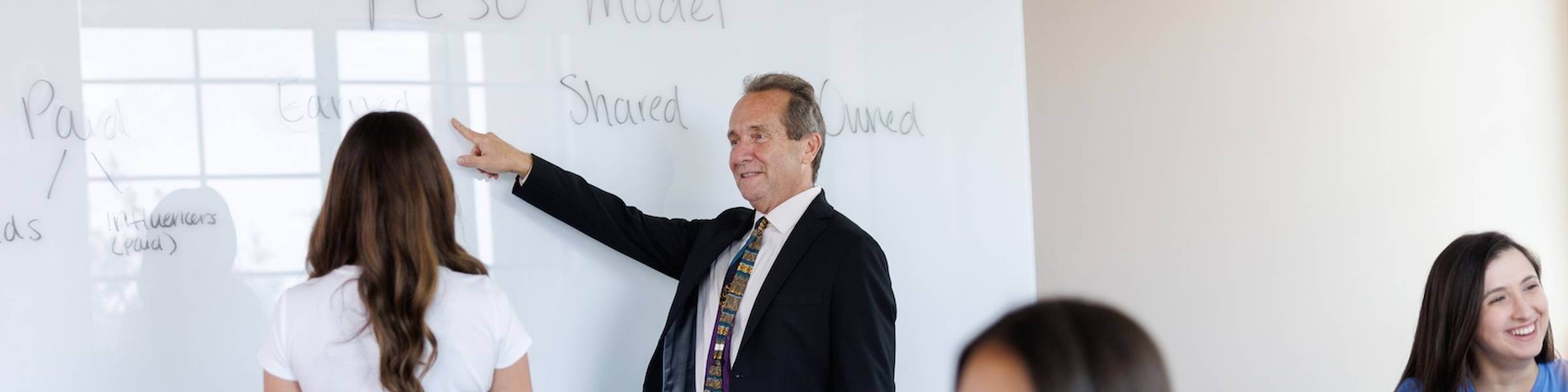 A communications professional leads a meeting with a group of colleagues.
