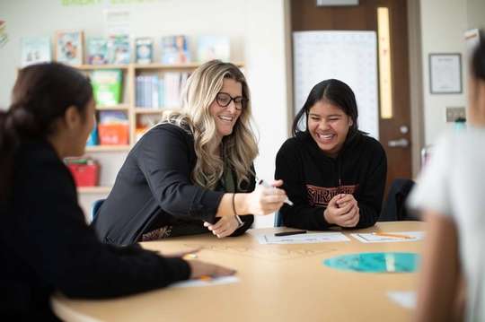 A teacher and student laugh together