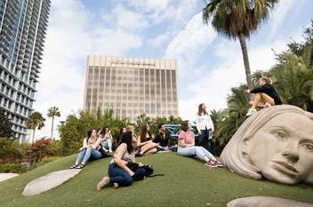 Students sitting on a large-scale sculpture in downtown Orlando