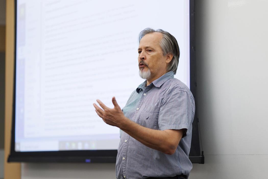 An international affairs professor lectures at the front of a classroom.