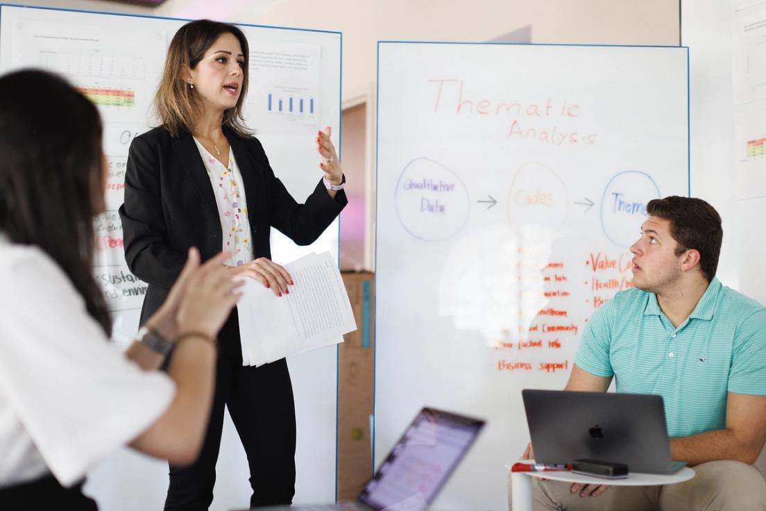 Business analytics professor and students work on a research project.