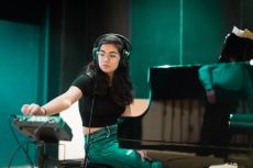 A Rollins music student plays a piano in a state-of-the-art recording studio.
