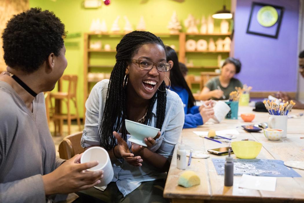 Students from EMBARK at a pottery making class, smiling and laughing