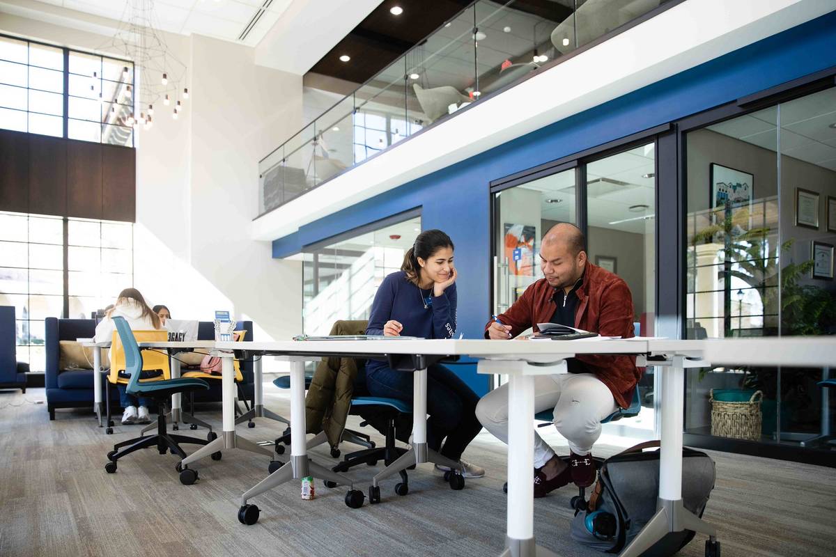 Two students work together at a table in Kathleen W. Rollins Hall.