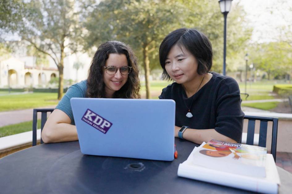 A Rollins education professor works one on one with a student.