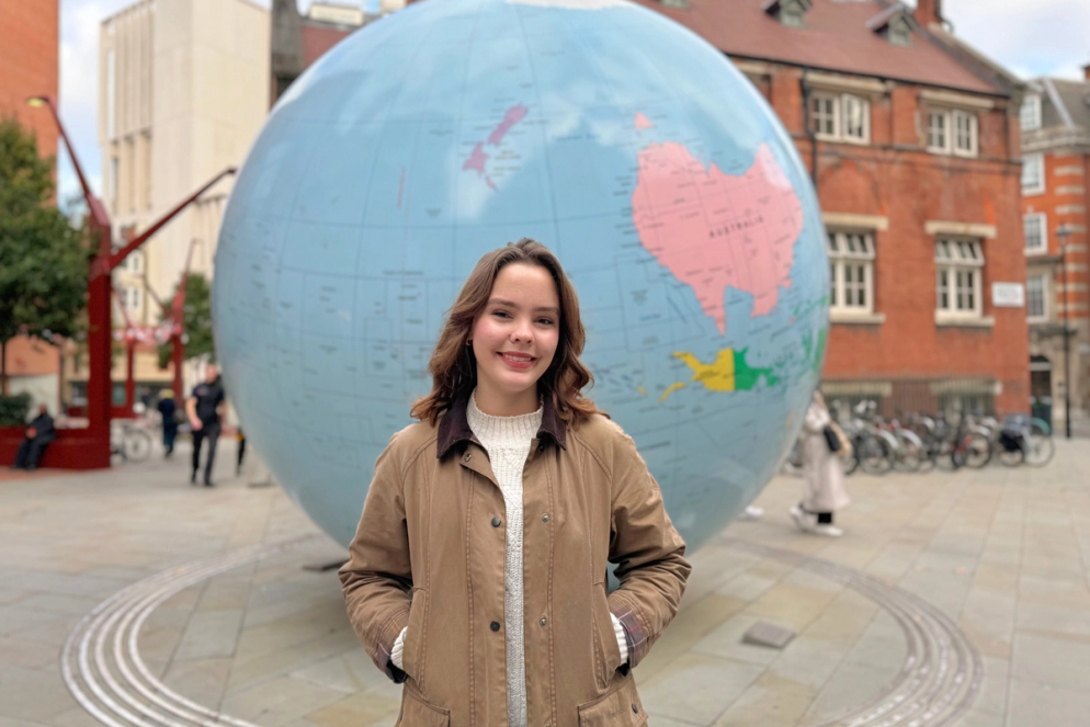 Ingrid Ryan standing in front of a globe in England
