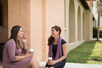 A college student chats with her mentor over coffee.