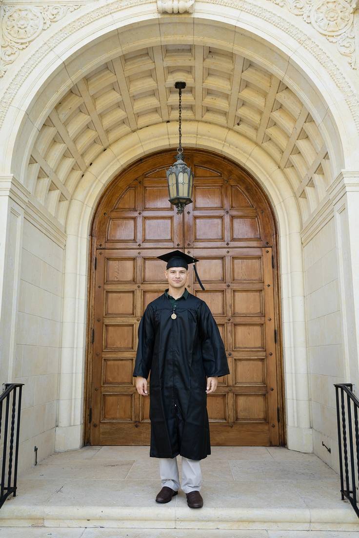 Tamer Elkhouly ’19 in graduation regalia in front of the Knowles Memorial Chapel at Rollins.