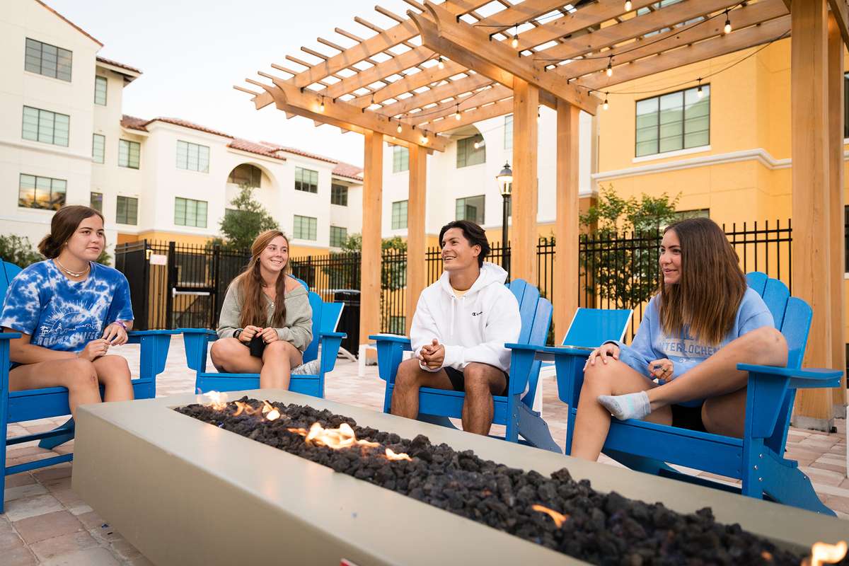Students relax at the fire pit near the pool in Lakeside Neighborhood.