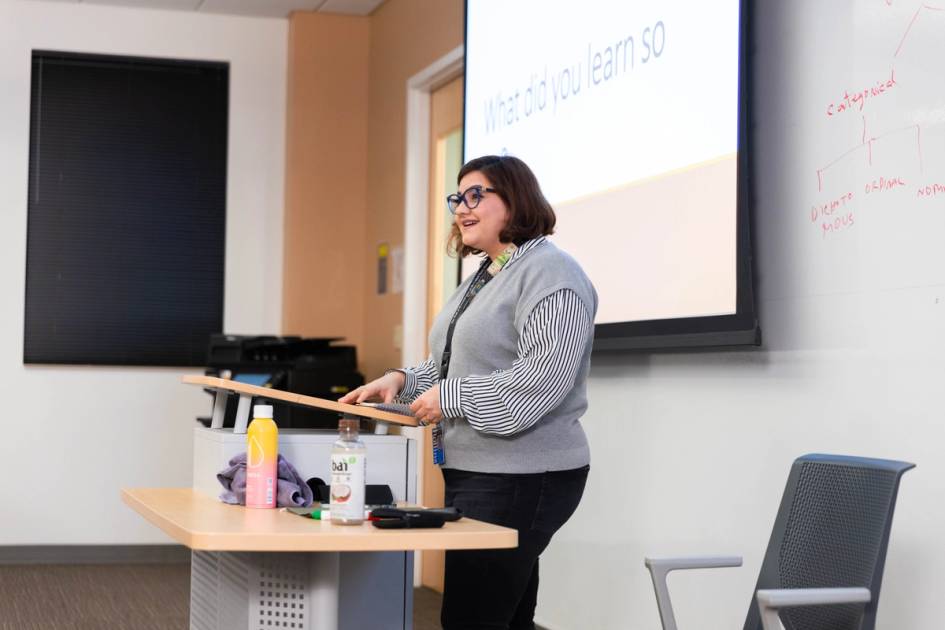 A public health professor explains a concept to a small class of students.