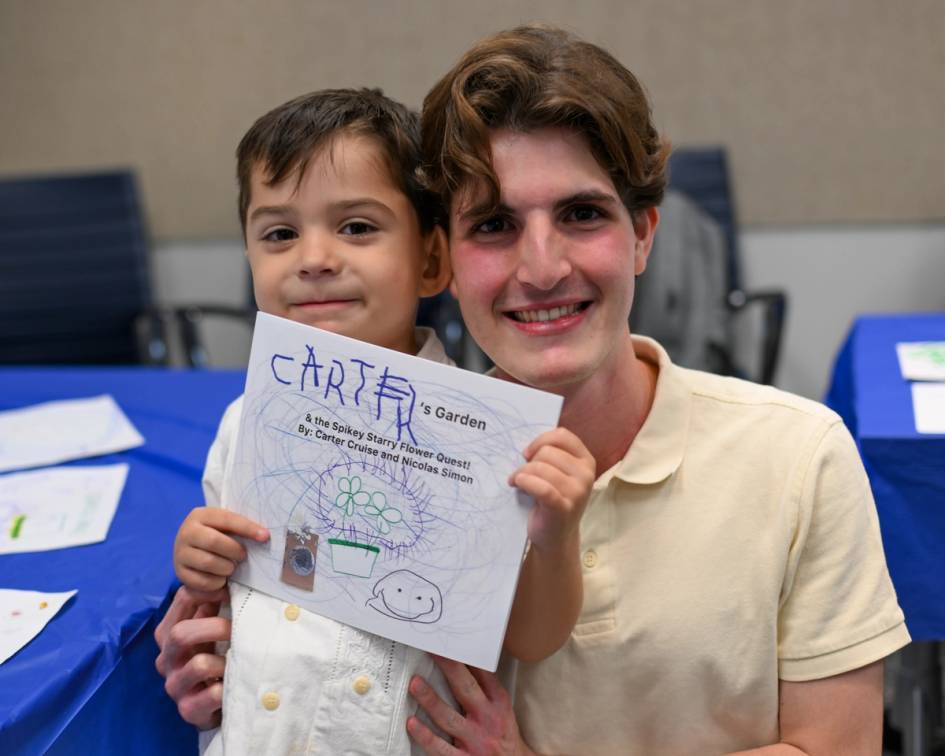 student and child posing with a book