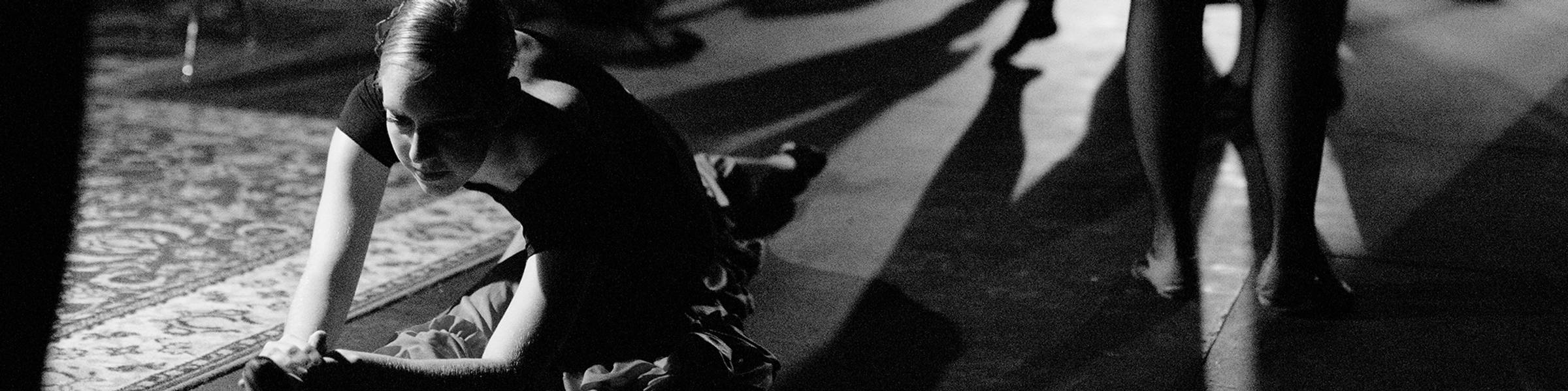 A student dancer stretches before class.