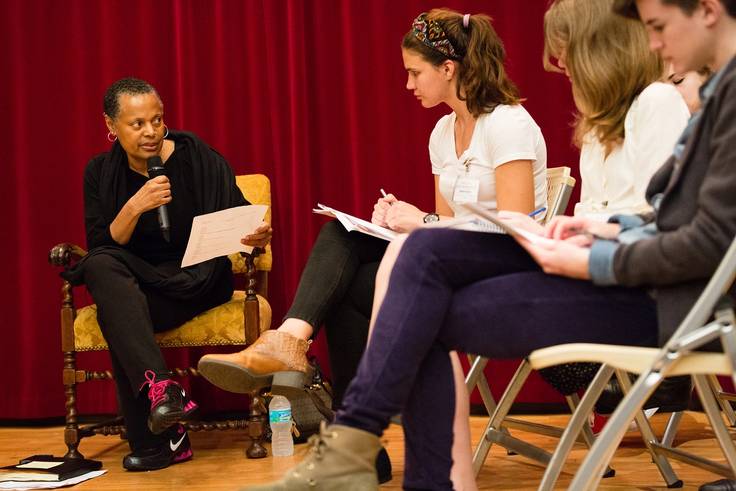 Rollins students discuss a book with a professor.