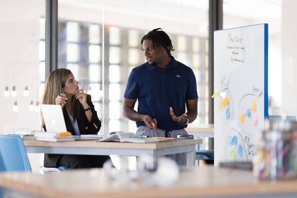 Social entrepreneurship professor and student brainstorm ideas in the Social Impact Hub.