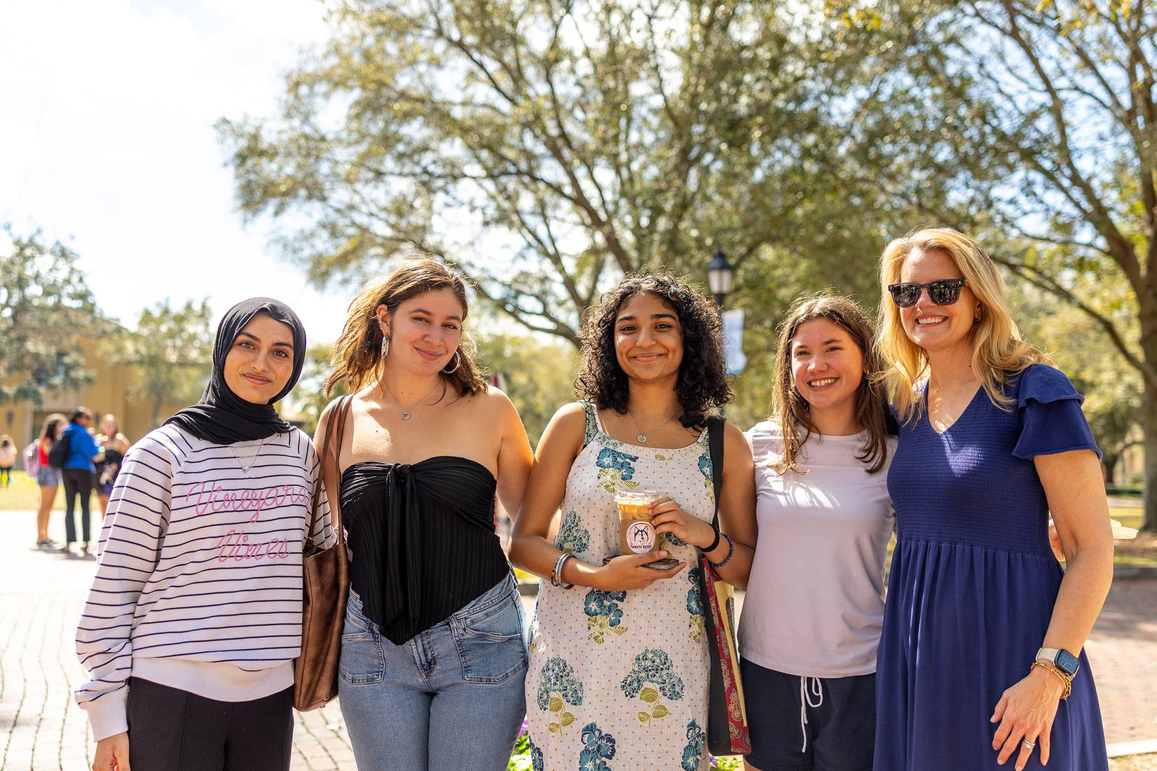 Rollins President Brooke Barnett poses with four women students.