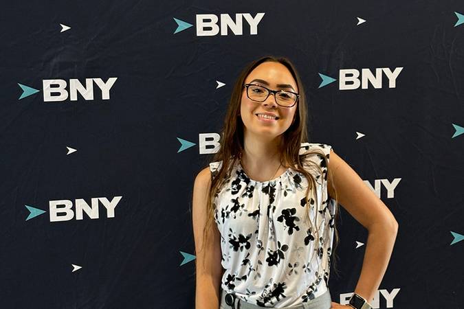 Saarah Valentin poses before a BNY-branded event backdrop.