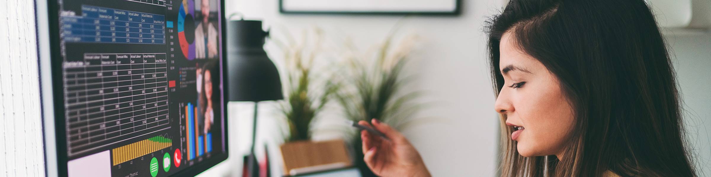 A financial analyst consults data on a tablet during a virtual meeting.
