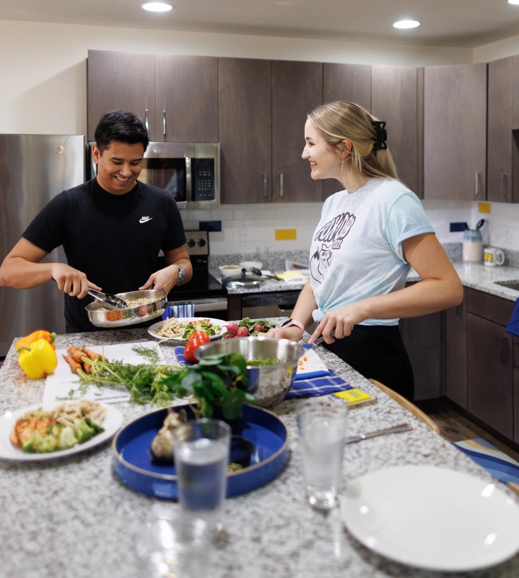 Two roommates prepare a meal kit together in their Lakeside Neighborhood dorm room.