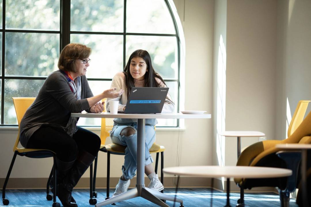 professional and student looking at a laptop in the accessibility services office