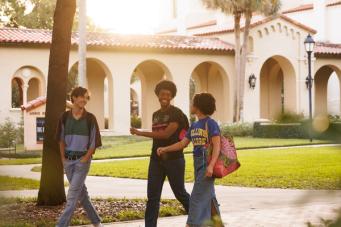 A group of Rollins college students walking on campus.
