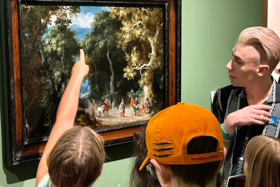 child points to a painting while adult and children look