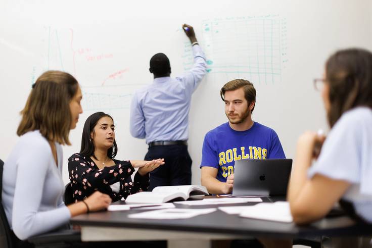 A group of Rollins students works on a data analytics project together. 