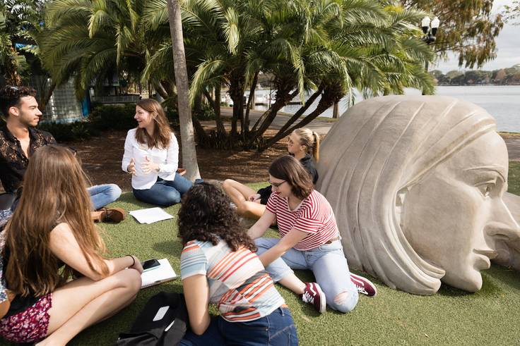 Rollins College students attend an art class in Lake Eola park.