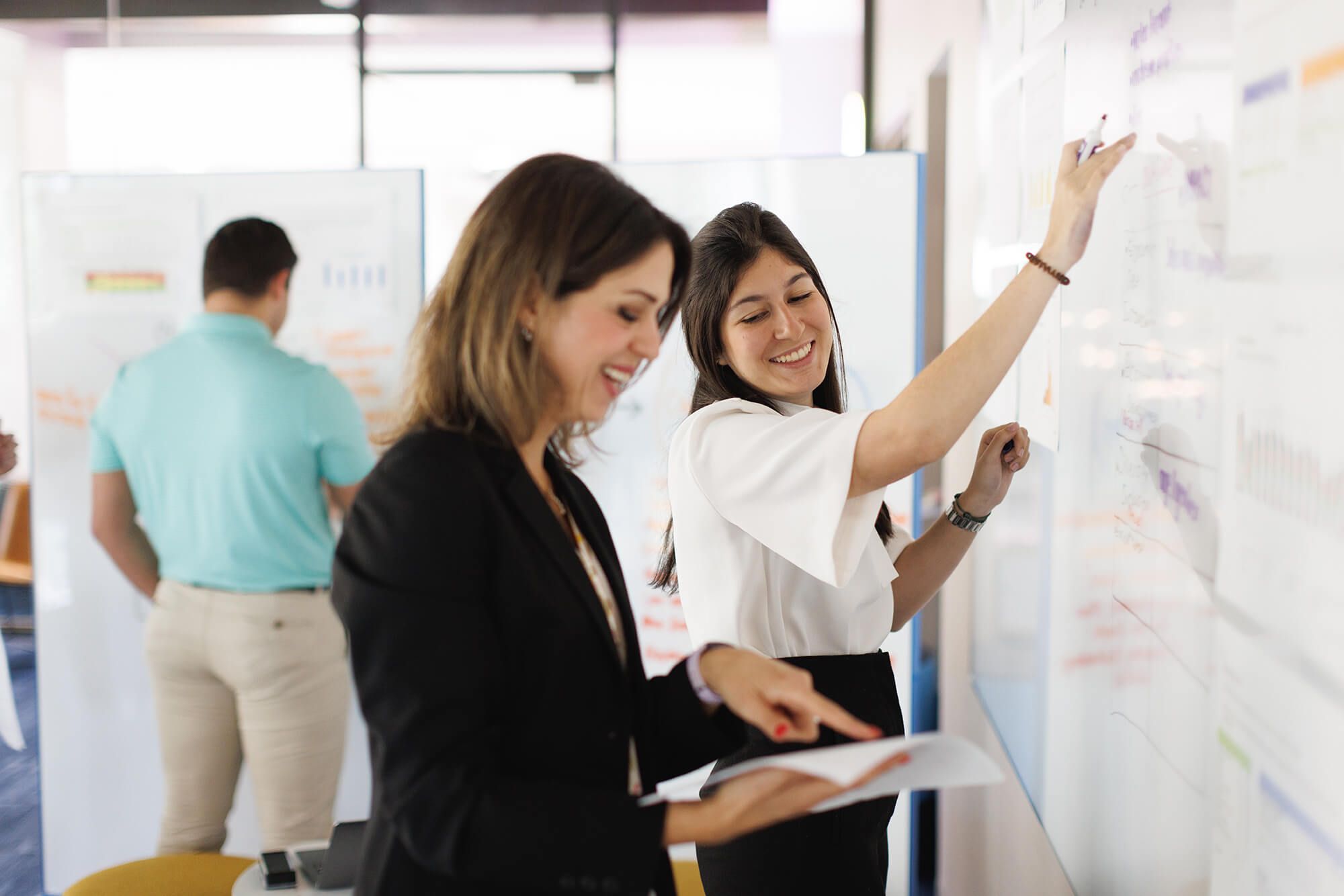 A professor and a student work together at a whiteboard.