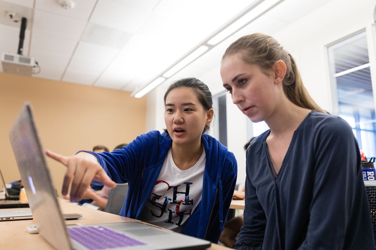 Two students collaborate on a class project.