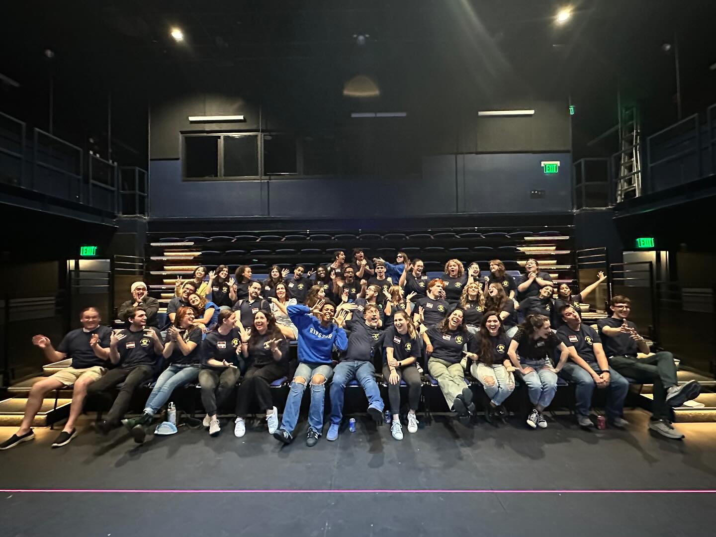A sea of blue shirts and big smiles as the whole crew strikes goofy poses together.