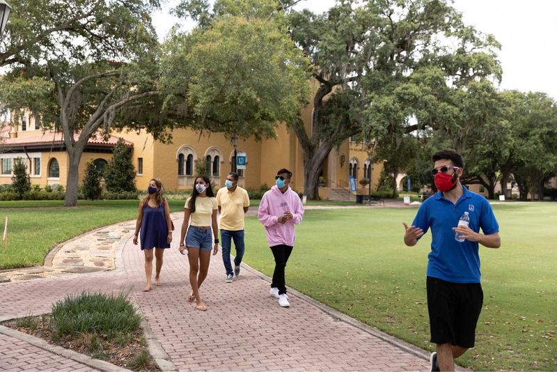 A tour guide leads people through the Rollins campus.