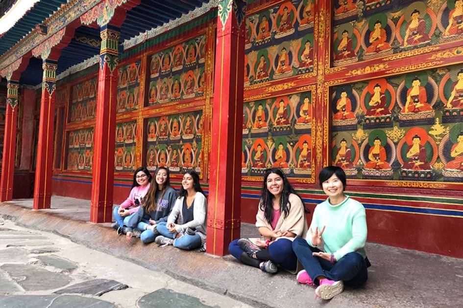 Rollins students site in front of a temple in China.