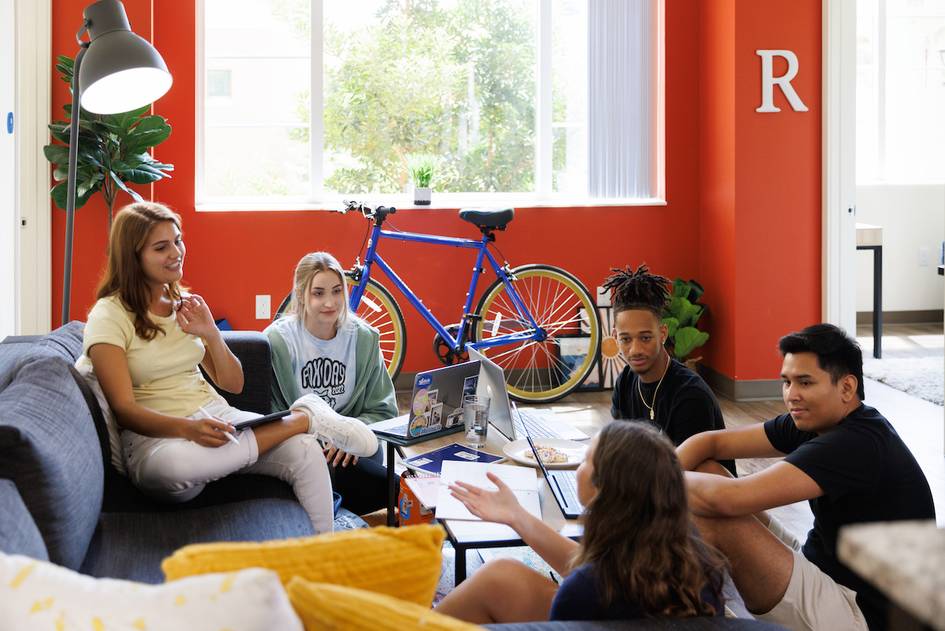 A group of students hanging out in a Lakeside apartment living room.