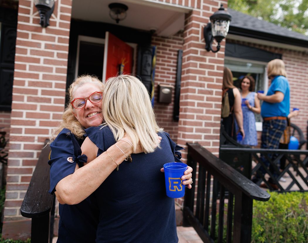 Two alumni hugging at Rollins in a Box party.