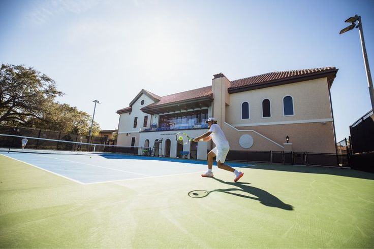 Rollins student-athlete hitting a forehand on outdoor court beside Rollins' new Tennis & Golf Center.