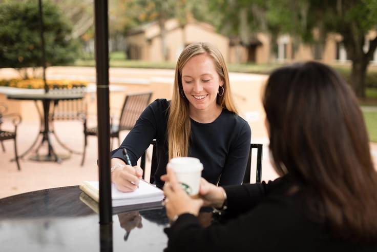 Student meets with her alumni mentor on Rollins campus.