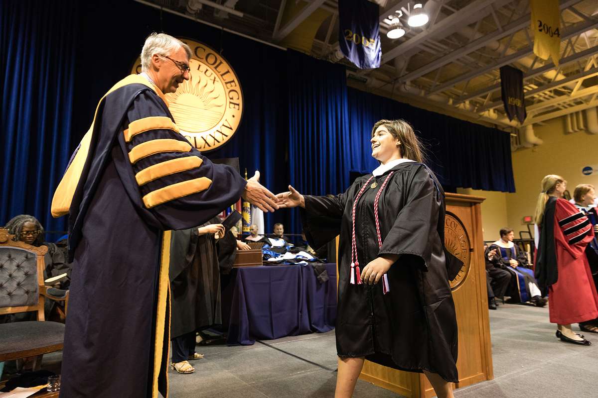 President Cornwell shakes hands with a Holt student.