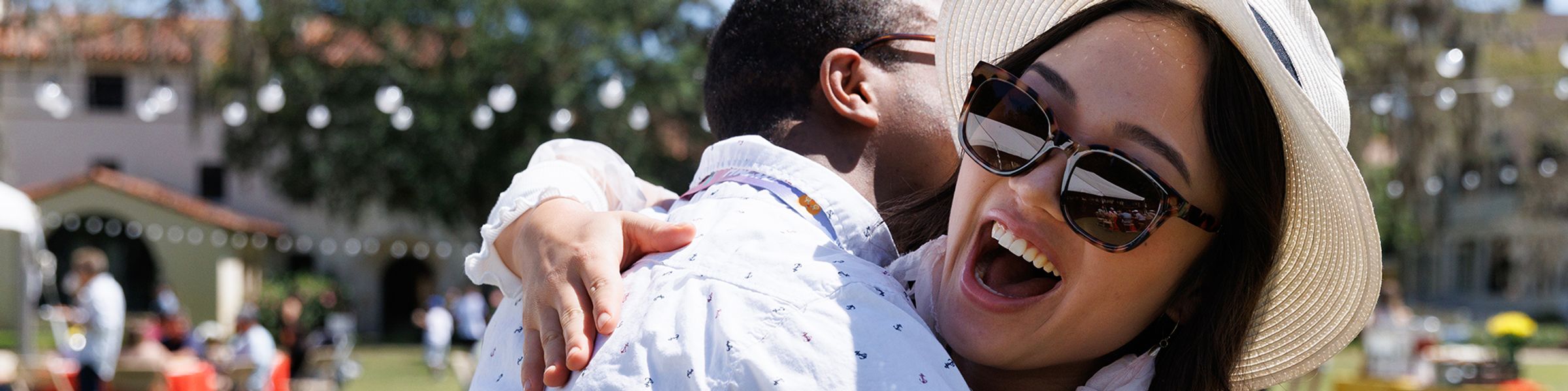 Two Rollins College alumni hug while on campus.