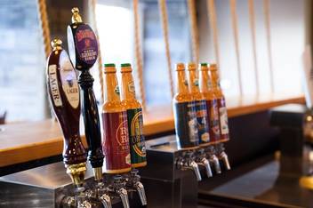 A bartender pouring a beer from a tap at Dave’s Boathouse.