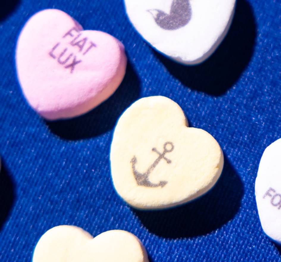 Green candy heart with an anchor silhouette on it.